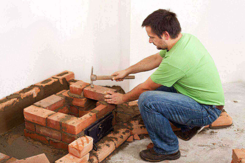 mason hammering bricks