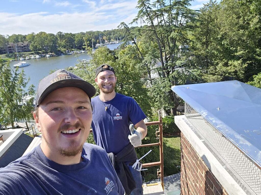 Chimney Techs on a roof of a home on a beautiful day.